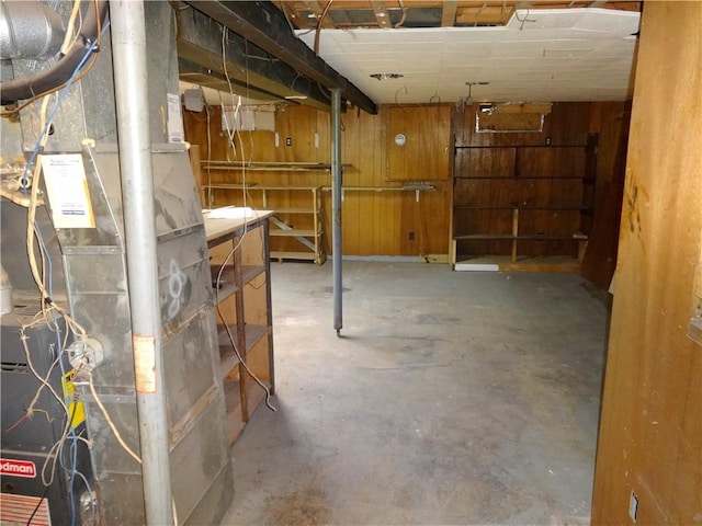 unfinished below grade area with heating unit and wooden walls