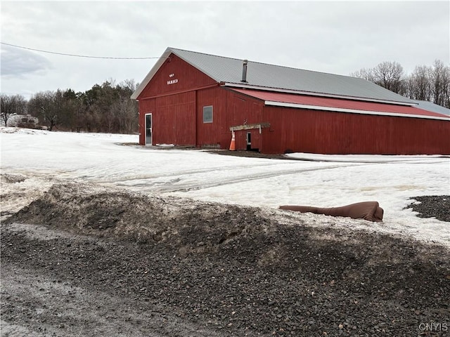 snow covered structure with an outdoor structure and an outbuilding