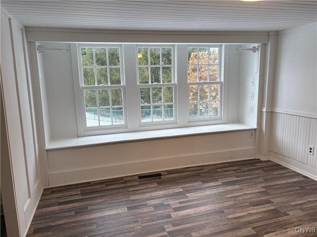 empty room featuring wainscoting and dark wood-style flooring