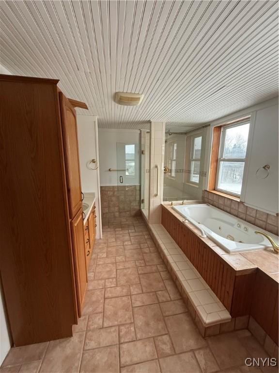 bathroom featuring a jetted tub, stone finish flooring, wood ceiling, a stall shower, and vanity