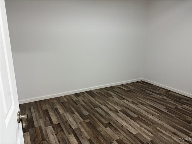 empty room with baseboards and dark wood-style flooring