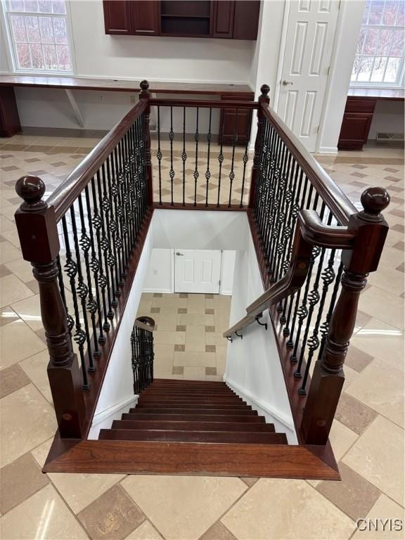 staircase featuring stone tile floors, visible vents, and baseboards