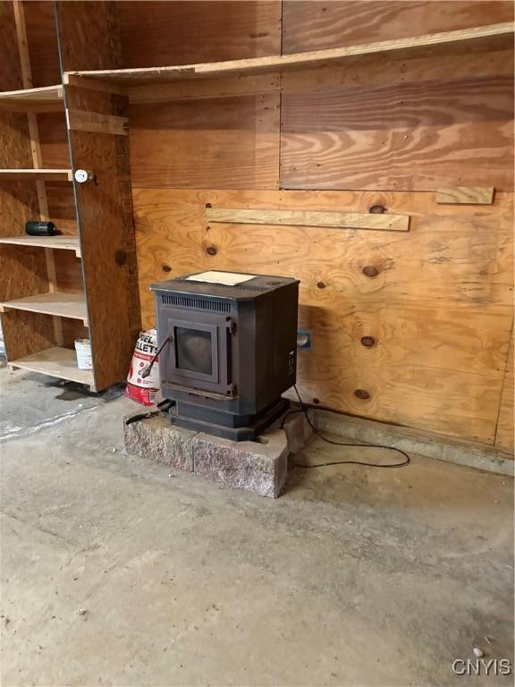 interior details with a wood stove and unfinished concrete flooring