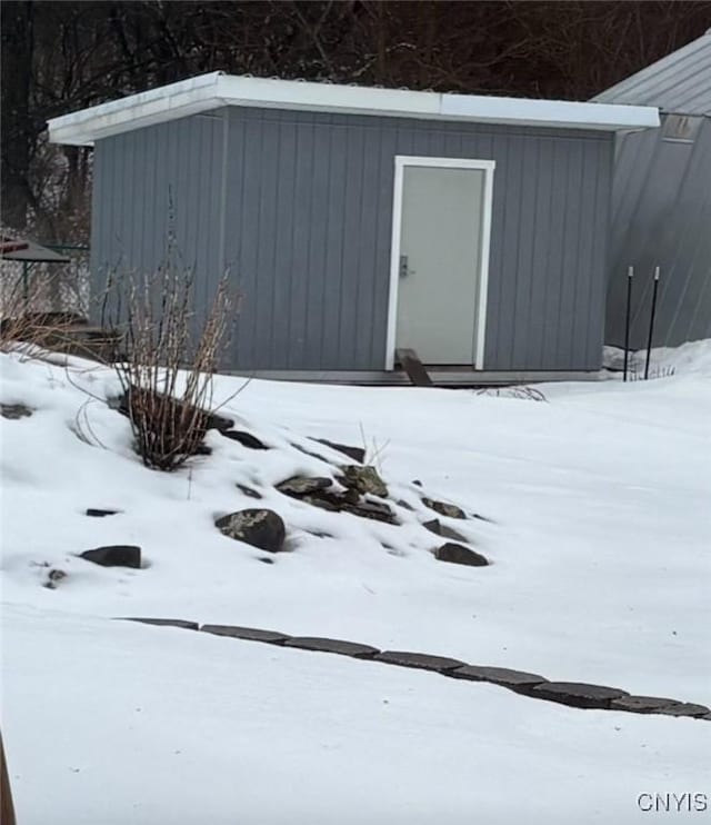 snow covered structure with an outdoor structure and a storage unit