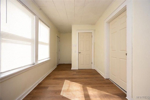 corridor with wood finished floors and baseboards