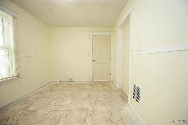 spare room with visible vents and a textured ceiling