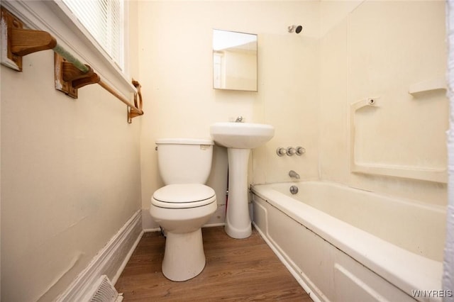 bathroom with toilet, shower / bath combo, baseboards, and wood finished floors