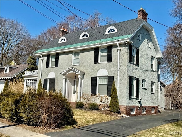 view of front of property with a shingled roof and a chimney