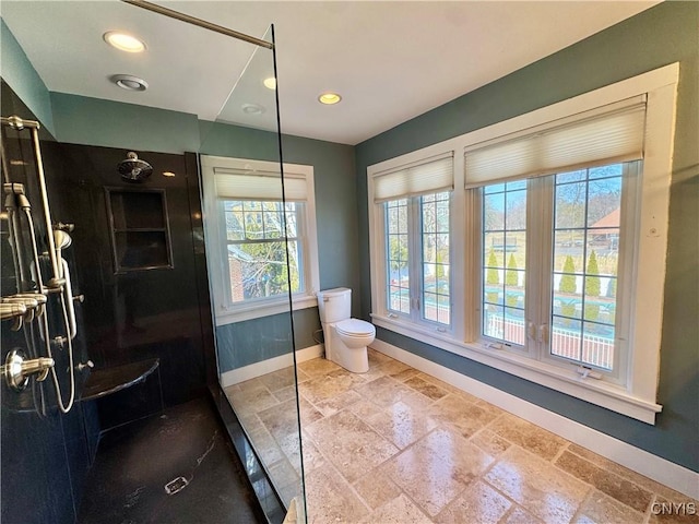 full bathroom with toilet, a walk in shower, stone tile flooring, recessed lighting, and baseboards