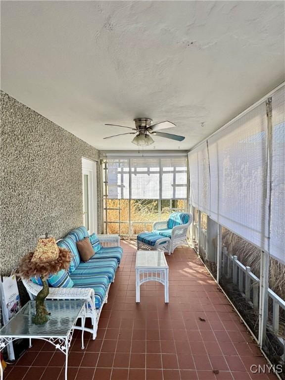 sunroom / solarium featuring ceiling fan