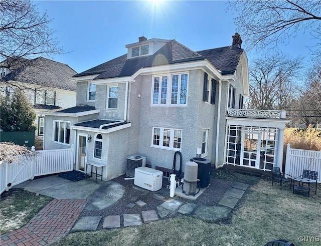 back of property featuring central air condition unit, a chimney, a patio, and fence