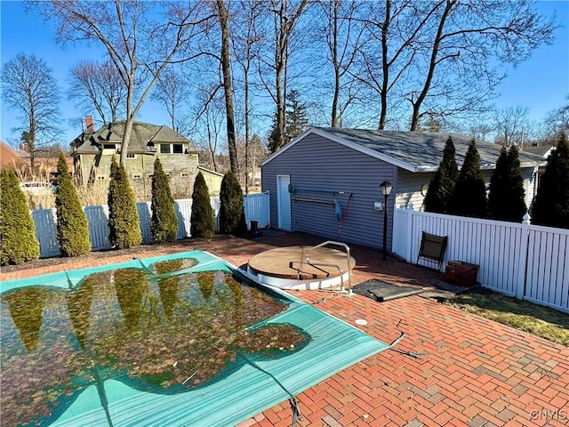 view of swimming pool with a patio and fence