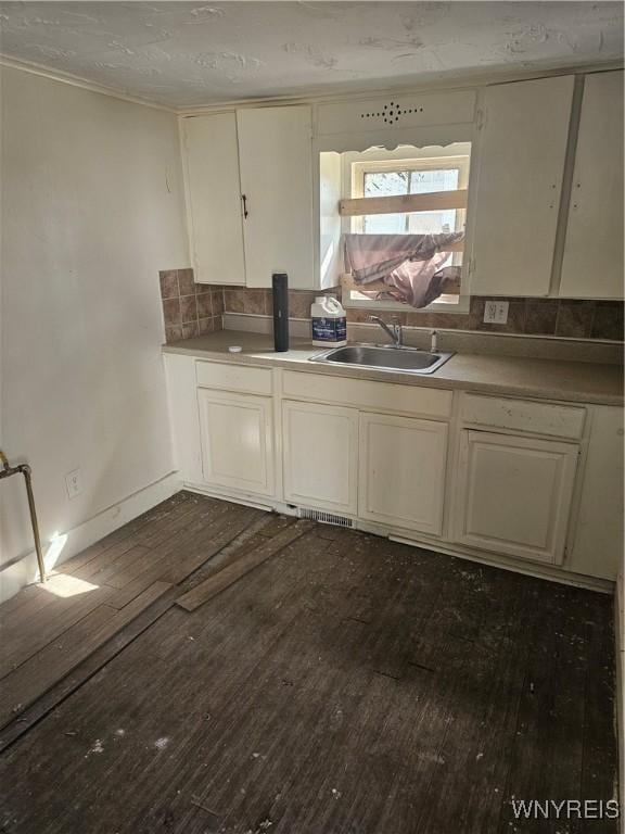 kitchen with a sink, cream cabinetry, and dark wood-style flooring