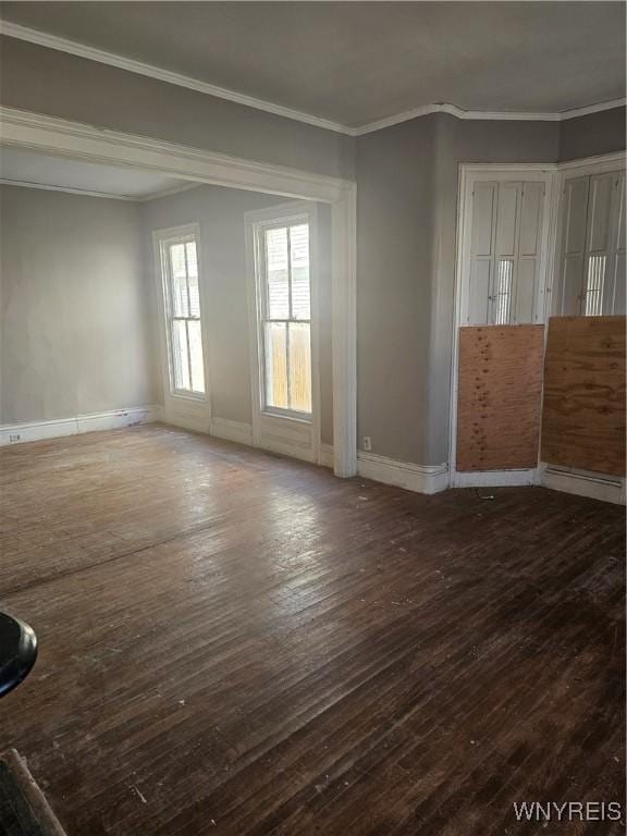 unfurnished room with baseboards, wood-type flooring, and ornamental molding