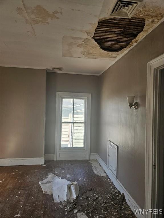 interior space with visible vents, baseboards, and ornamental molding