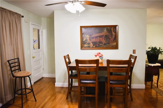 dining area with wood finished floors, baseboards, and ceiling fan