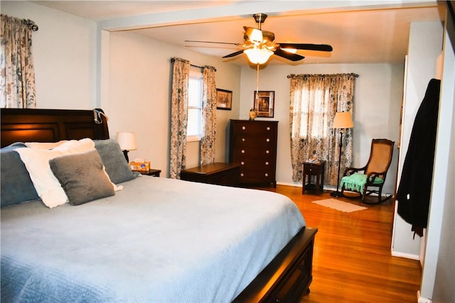 bedroom with ceiling fan, baseboards, and wood finished floors