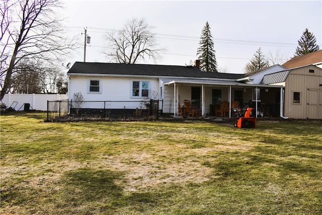 rear view of house featuring an outbuilding, fence, a yard, a storage shed, and a chimney