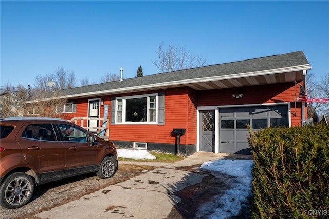 view of front of property featuring an attached garage and a shingled roof