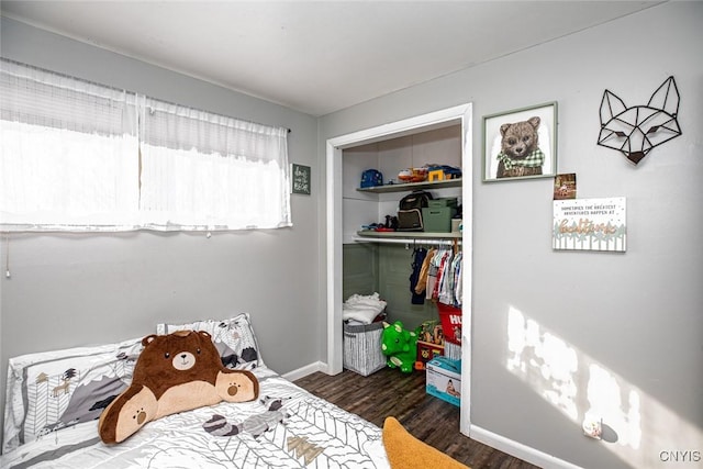 bedroom with a closet, baseboards, and wood finished floors