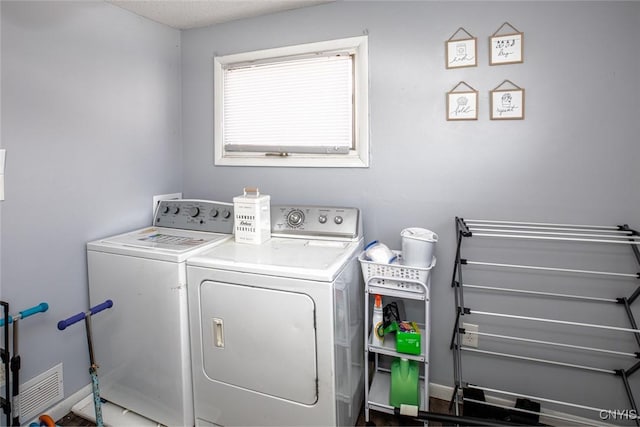 laundry area with washing machine and clothes dryer, laundry area, baseboards, and visible vents