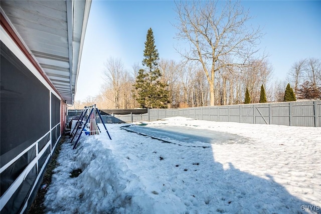 yard layered in snow featuring a fenced backyard