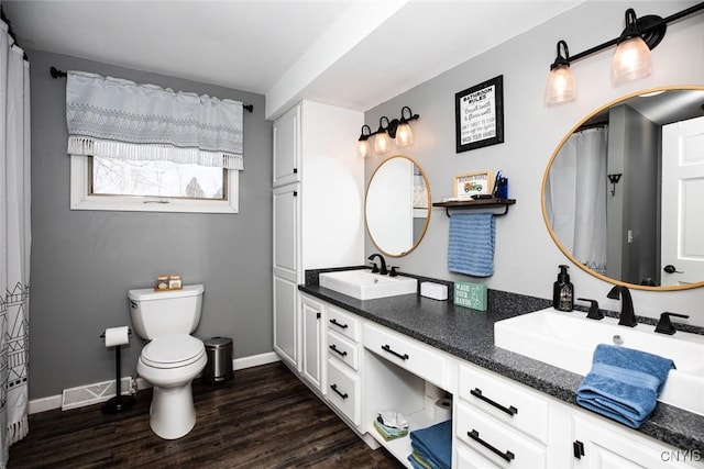 full bath featuring toilet, wood finished floors, baseboards, and a sink