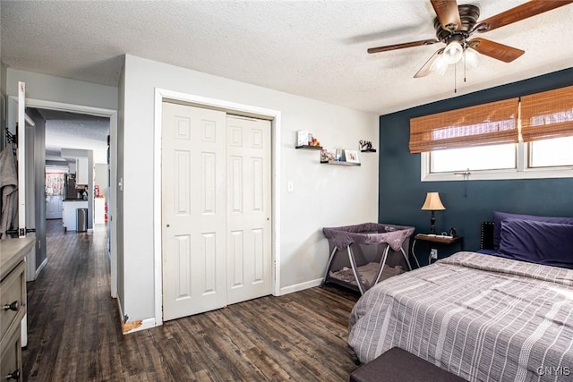 bedroom with a ceiling fan, a textured ceiling, a closet, baseboards, and dark wood-style flooring