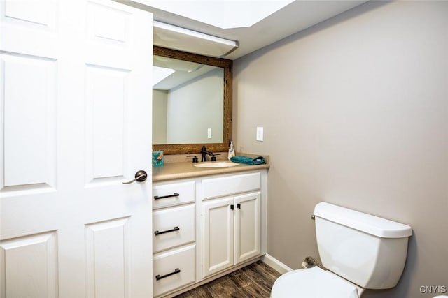 bathroom with toilet, wood finished floors, and vanity