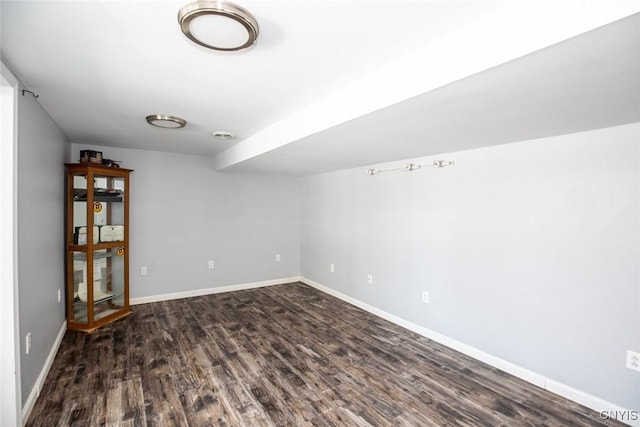 spare room with dark wood-style floors and baseboards