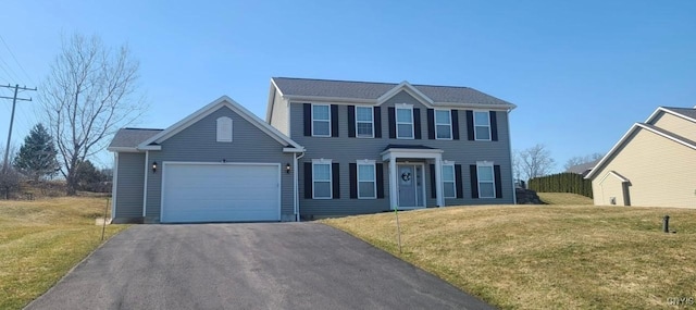 colonial home featuring aphalt driveway, a front lawn, and a garage