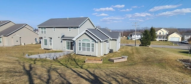 rear view of property with a residential view and a lawn