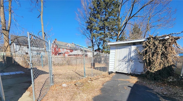 view of yard featuring a storage shed, an outdoor structure, and fence