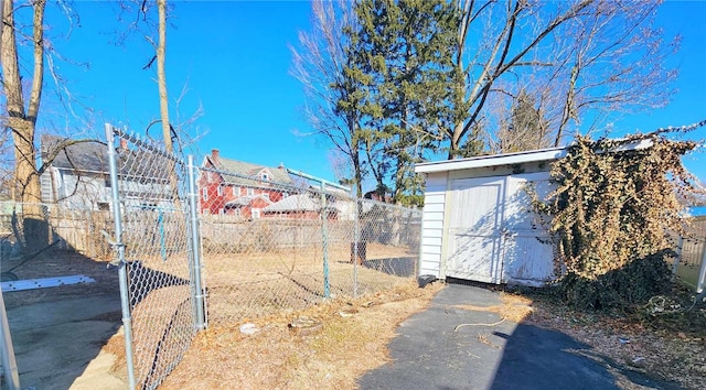 view of yard featuring a storage shed, an outdoor structure, and fence