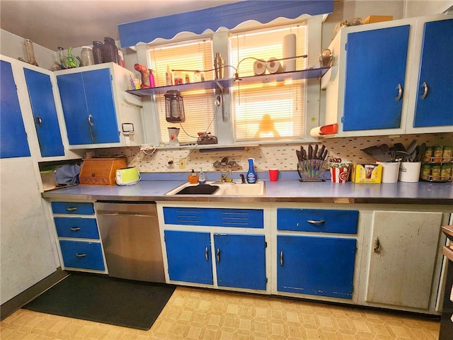 kitchen with blue cabinetry, a sink, backsplash, light floors, and dishwasher