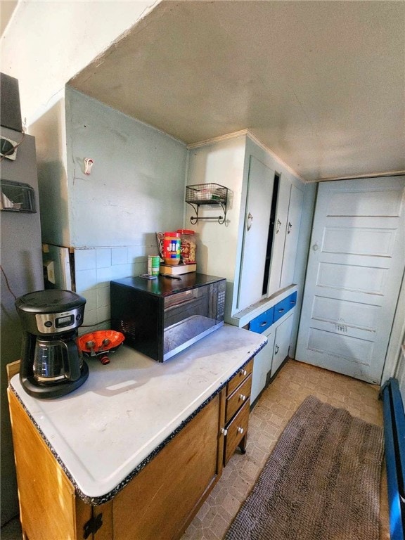 kitchen with light countertops, light floors, and brown cabinets