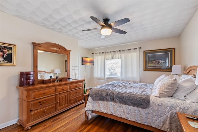 bedroom with baseboards, wood finished floors, and a ceiling fan