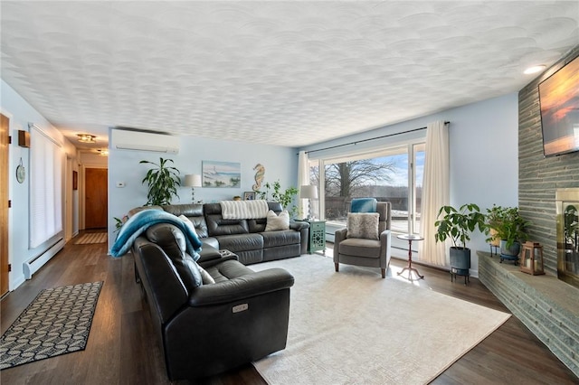 living area with baseboard heating, a textured ceiling, a wall mounted AC, and wood finished floors