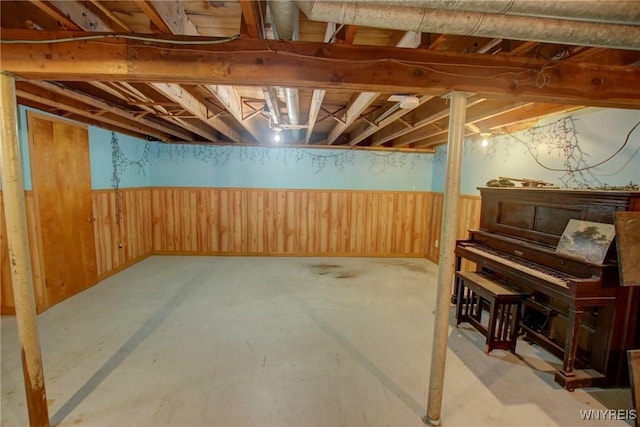 unfinished basement with wooden walls and wainscoting