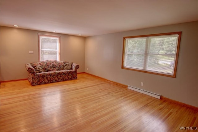 living area featuring recessed lighting, a baseboard radiator, baseboards, and wood finished floors