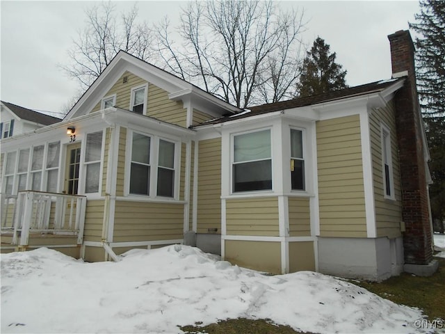 32 Fenner St, Cazenovia, NY 13035 - snow covered property featuring a chimney and a sunroom