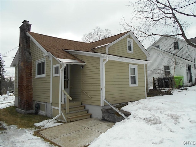 32 Fenner St, Cazenovia, NY 13035 - snow covered rear of property with roof with shingles and a chimney