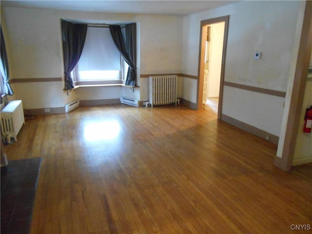 32 Fenner St, Cazenovia, NY 13035 - empty room with baseboard heating, radiator, and wood finished floors