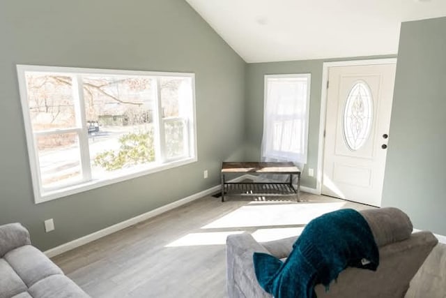 interior space with wood finished floors, baseboards, and vaulted ceiling