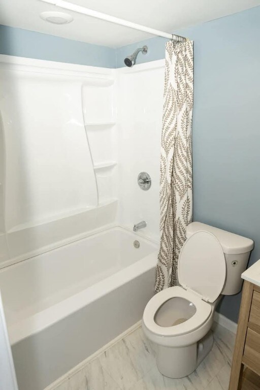 full bathroom with vanity, toilet, shower / bathtub combination with curtain, and marble finish floor