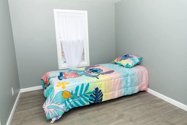 bedroom featuring baseboards and wood finished floors