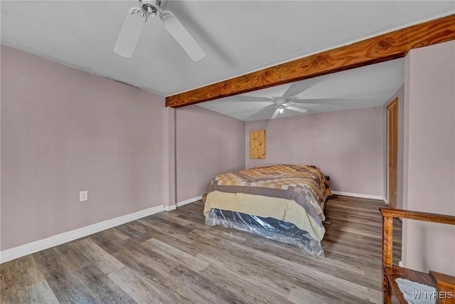 bedroom with baseboards, beam ceiling, wood finished floors, and a ceiling fan