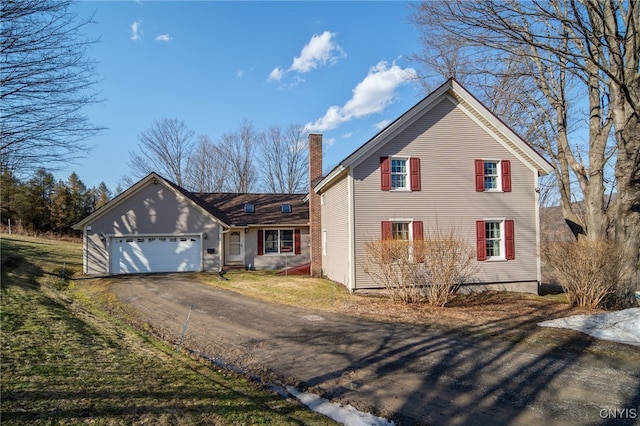 traditional home with aphalt driveway, a chimney, a garage, and a front yard