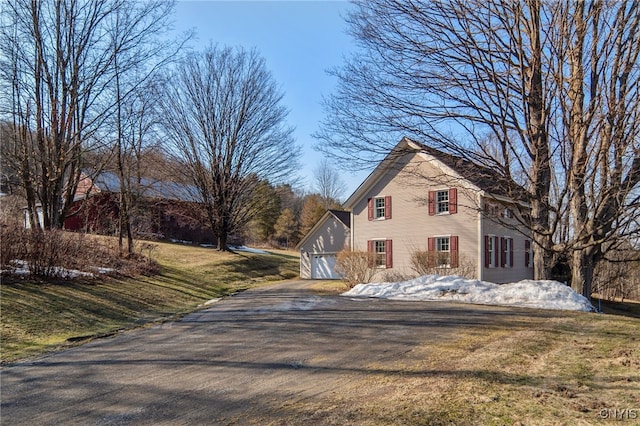 view of front of property featuring driveway, a front lawn, and a garage