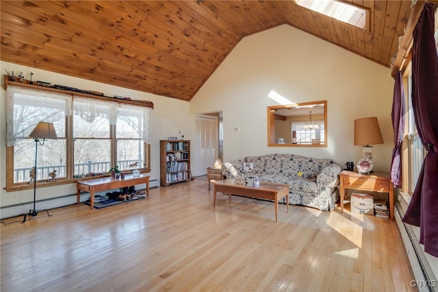 living area featuring plenty of natural light, baseboard heating, wood finished floors, and high vaulted ceiling